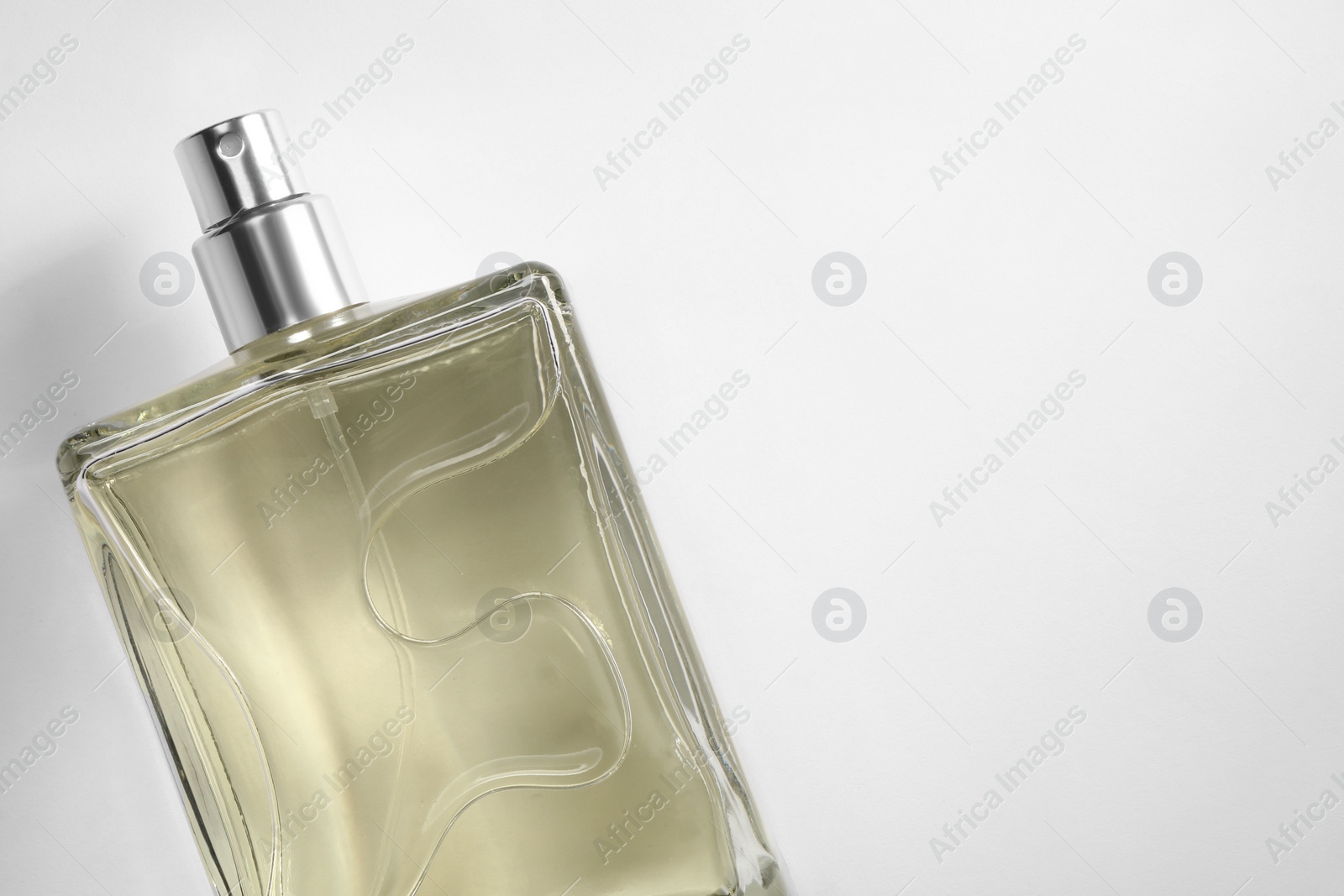 Photo of Luxury men`s perfume in bottle on white background, top view. Space for text