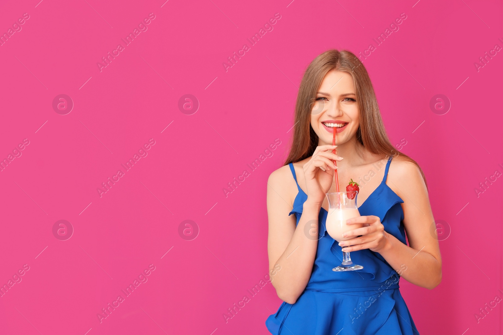 Photo of Young woman with glass of delicious milk shake on color background