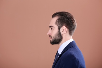 Portrait of young businessman with beautiful hair on color background