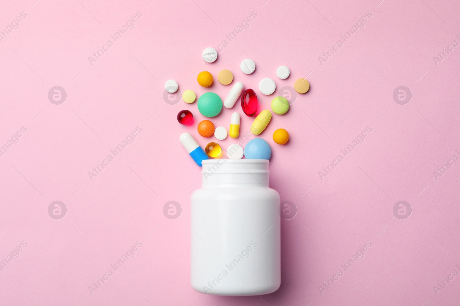 Photo of Bottle with different pills on color background, flat lay