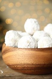 Photo of Tasty snowball cookies in wooden bowl, closeup. Christmas treat