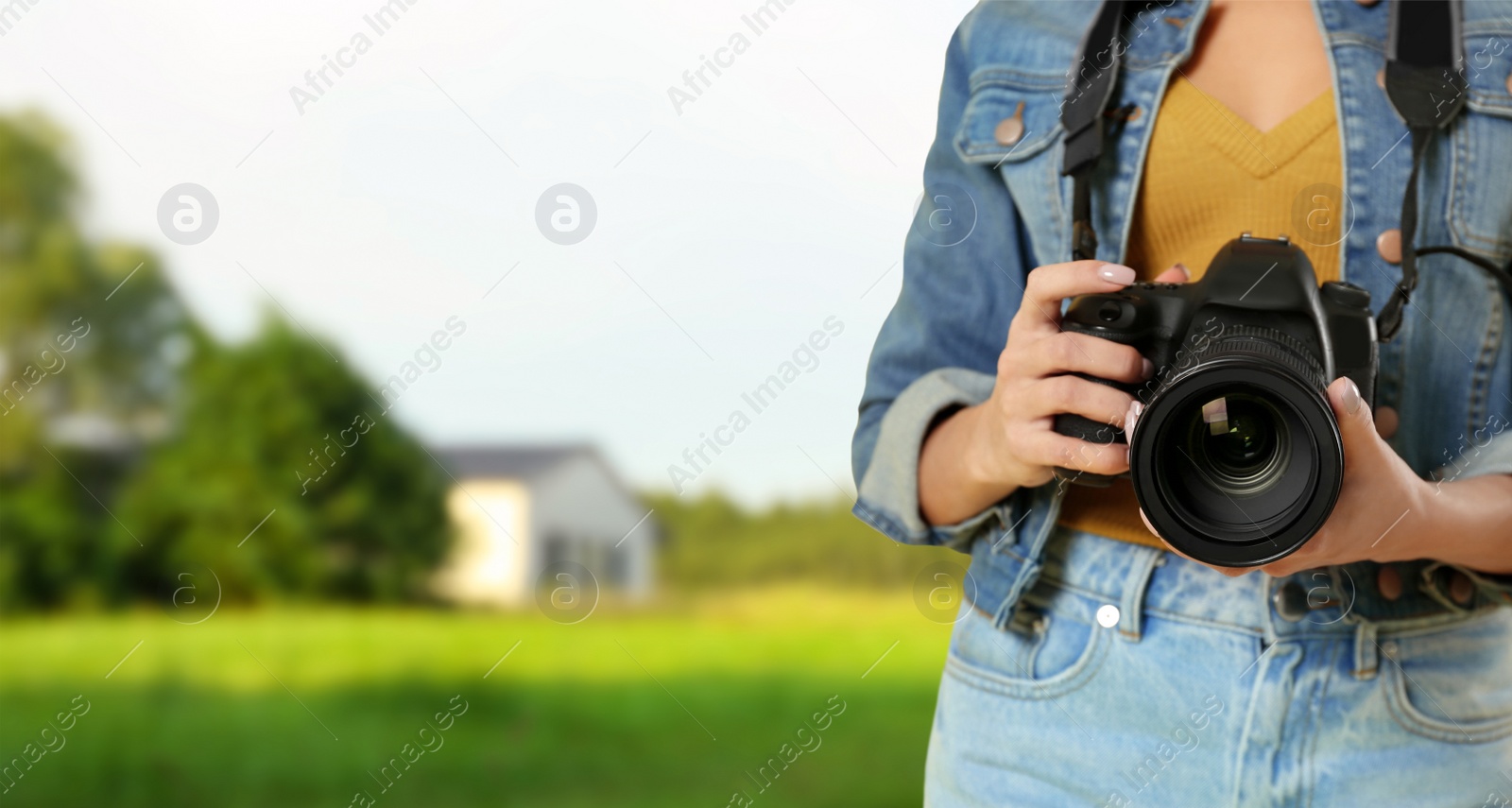 Image of Professional photographer with modern camera and blurred view of landscape, space for text. Banner design