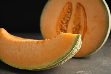 Photo of Slice of tasty fresh melon on grey table, closeup