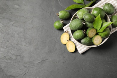 Photo of Flat lay composition with fresh green feijoa fruits on black table, space for text