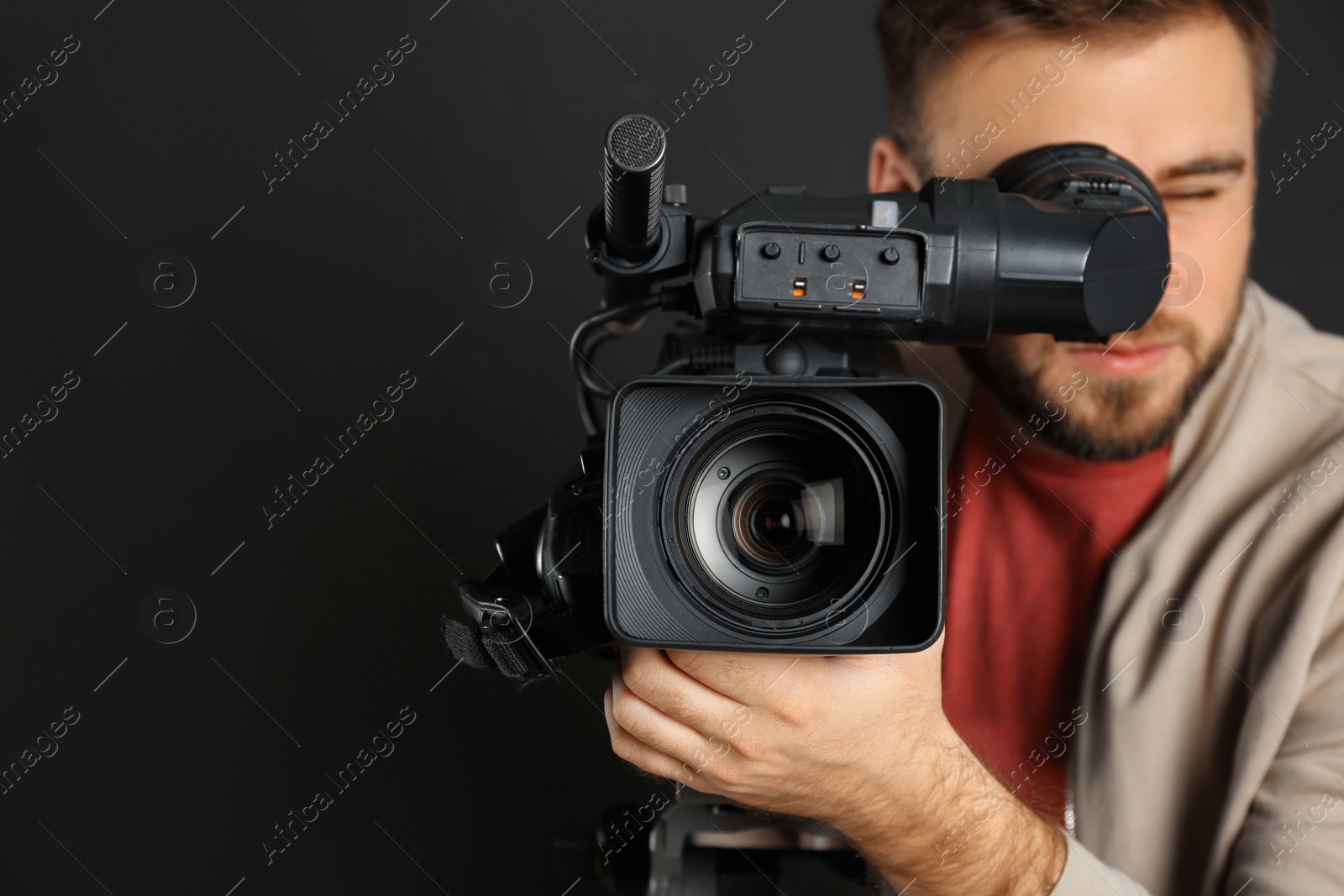 Photo of Operator with professional video camera on black background