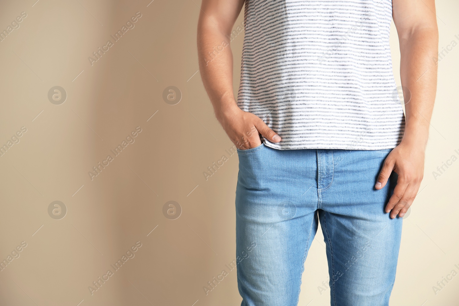 Photo of Young man in stylish jeans on light background
