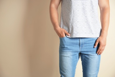 Young man in stylish jeans on light background