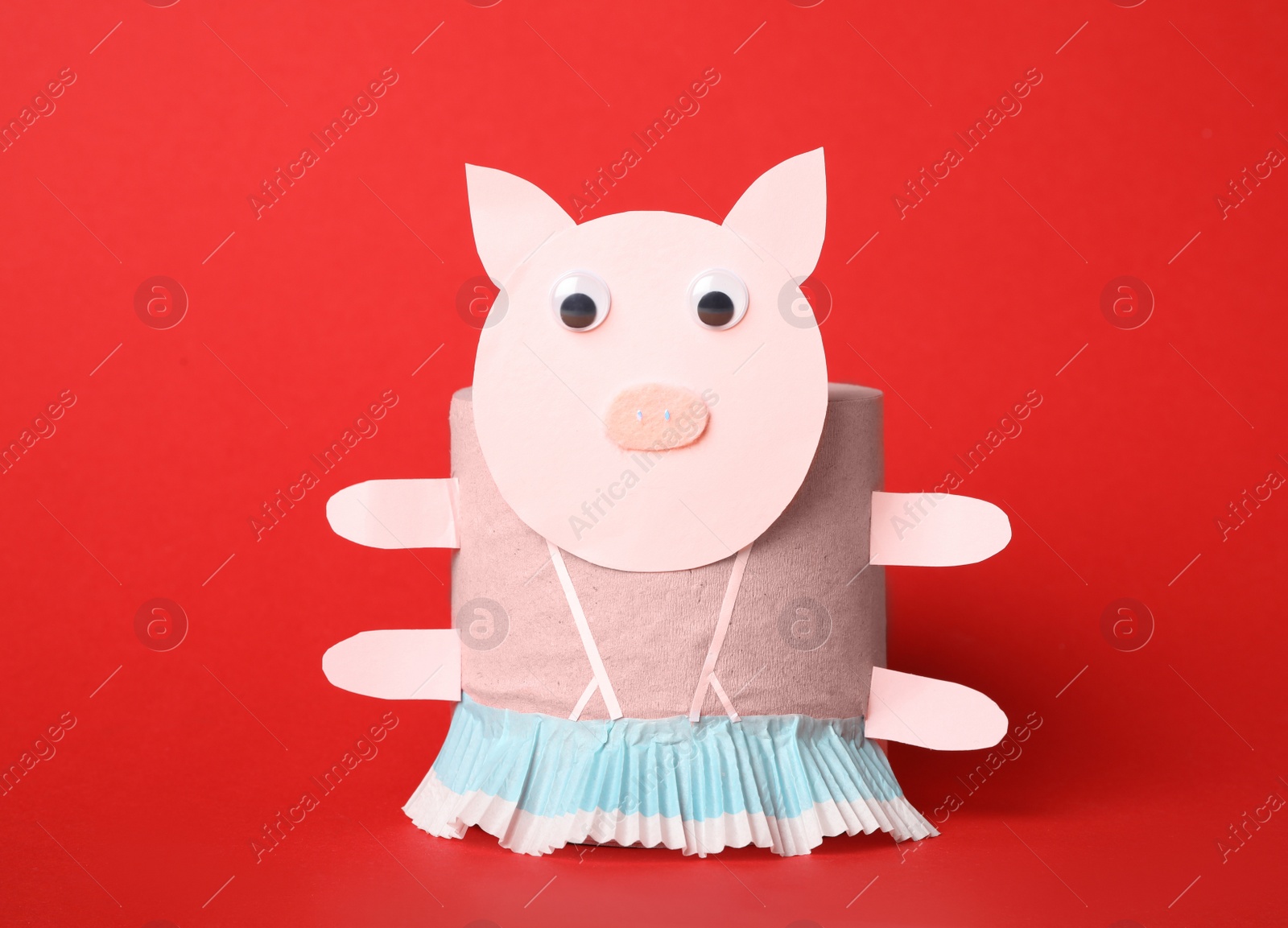 Photo of Toy pig made of toilet paper roll on red background