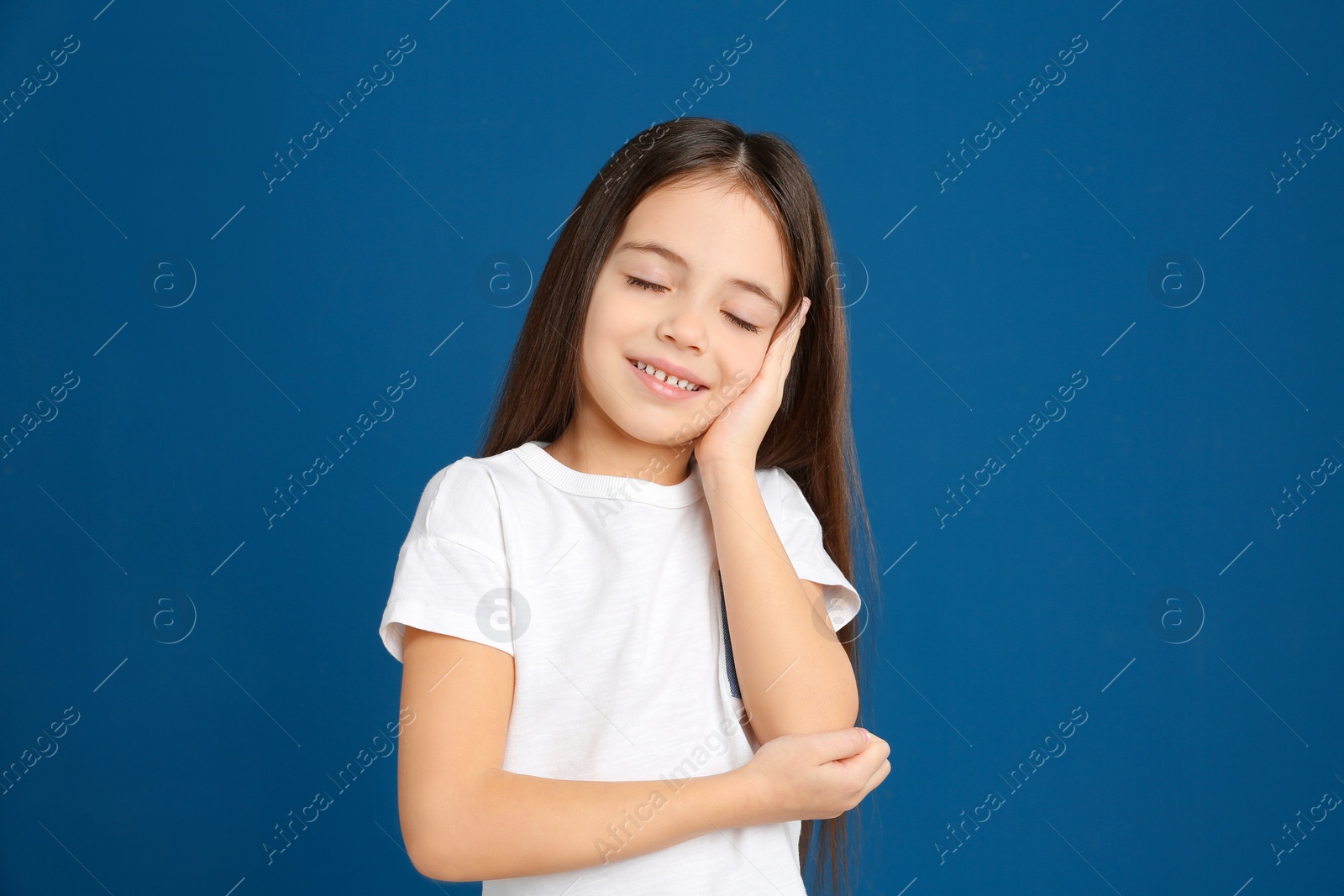 Photo of Portrait of cute little girl on blue background