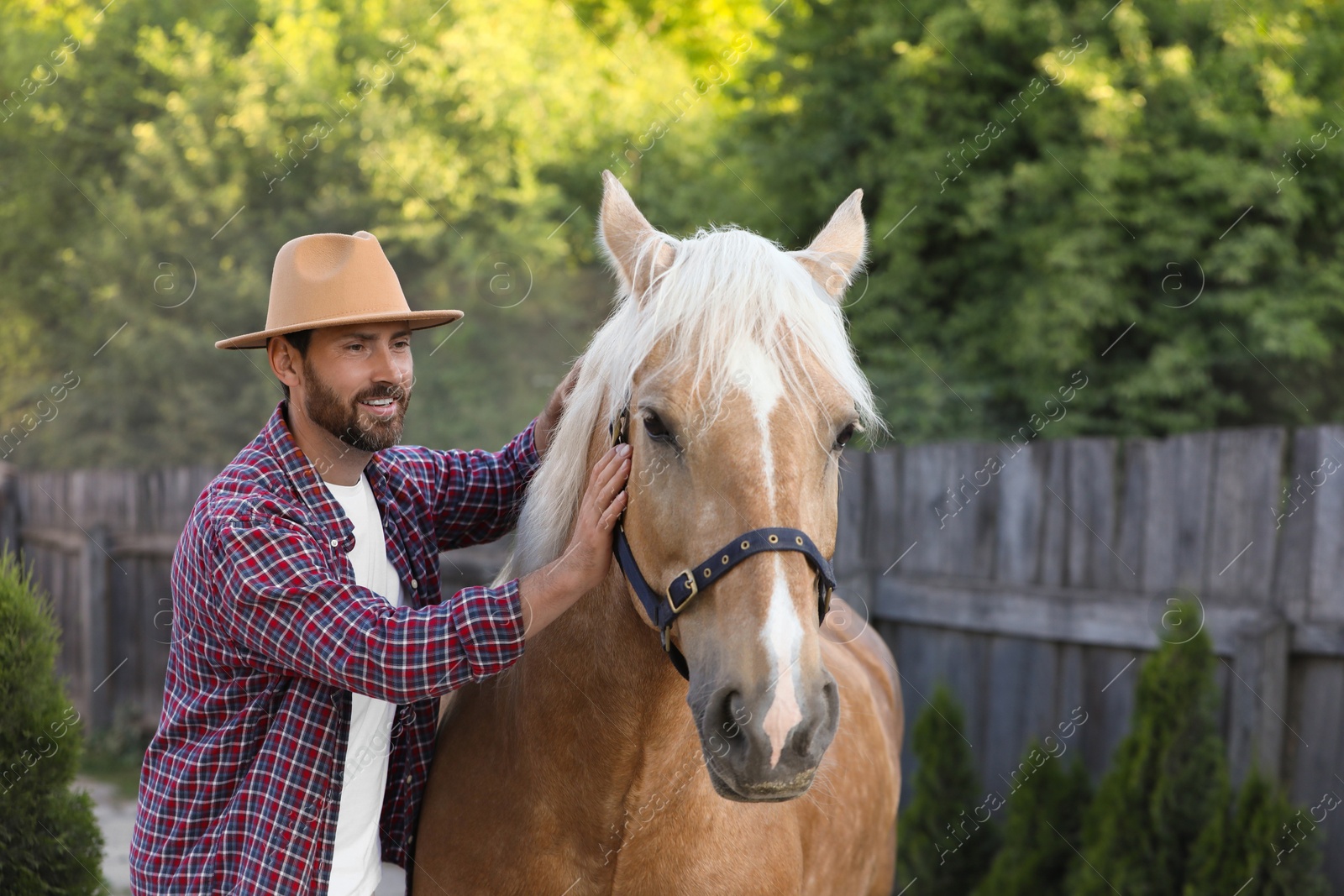 Photo of Handsome man with adorable horse outdoors. Lovely domesticated pet