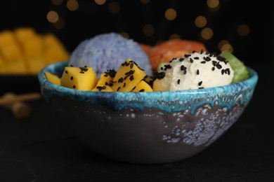 Photo of Delicious poke bowl on table against blurred lights, closeup