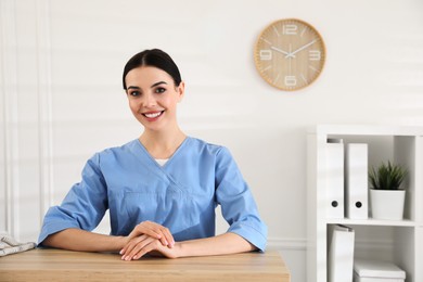 Portrait of receptionist at countertop in hospital