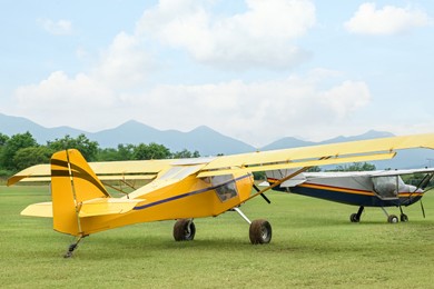 View of beautiful ultralight airplanes in field on autumn day