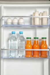 Photo of Different fresh products on shelves in refrigerator