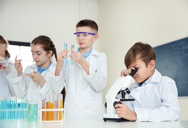 Photo of Smart pupils making experiment in chemistry class