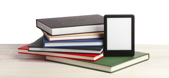 Stack of hardcover books and modern e-book on wooden table against white background