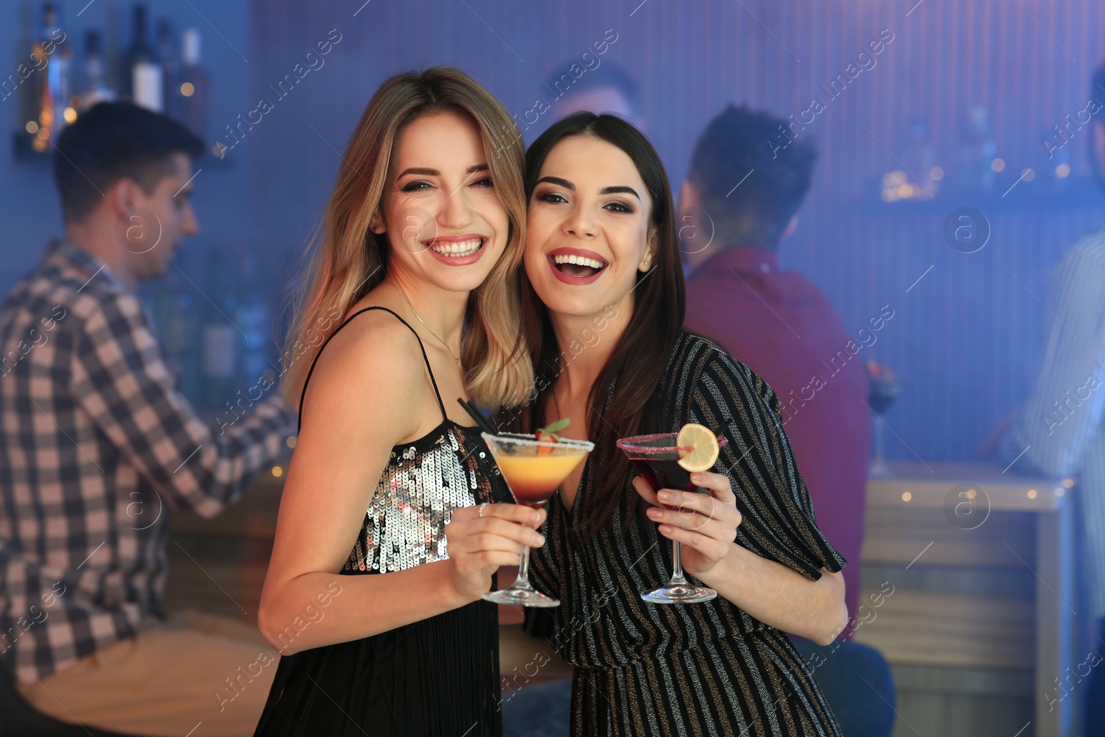 Photo of Beautiful young women with martini cocktails in bar