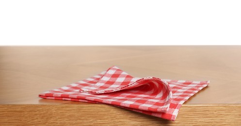 Checkered tablecloth on wooden table against white background