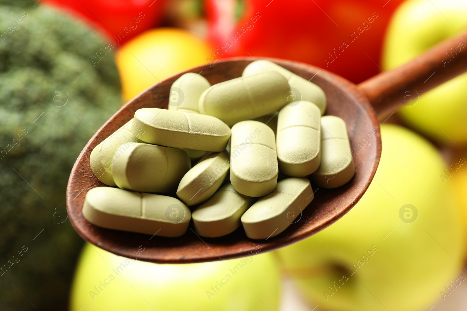 Photo of Dietary supplements. Spoon with pills over food products, closeup