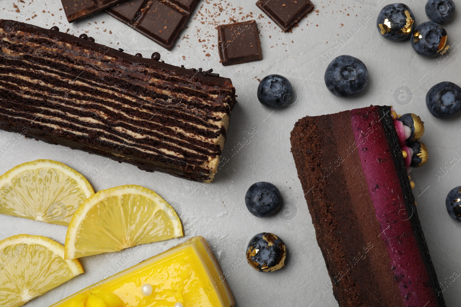 Photo of Flat lay composition with different tasty cakes on light grey table