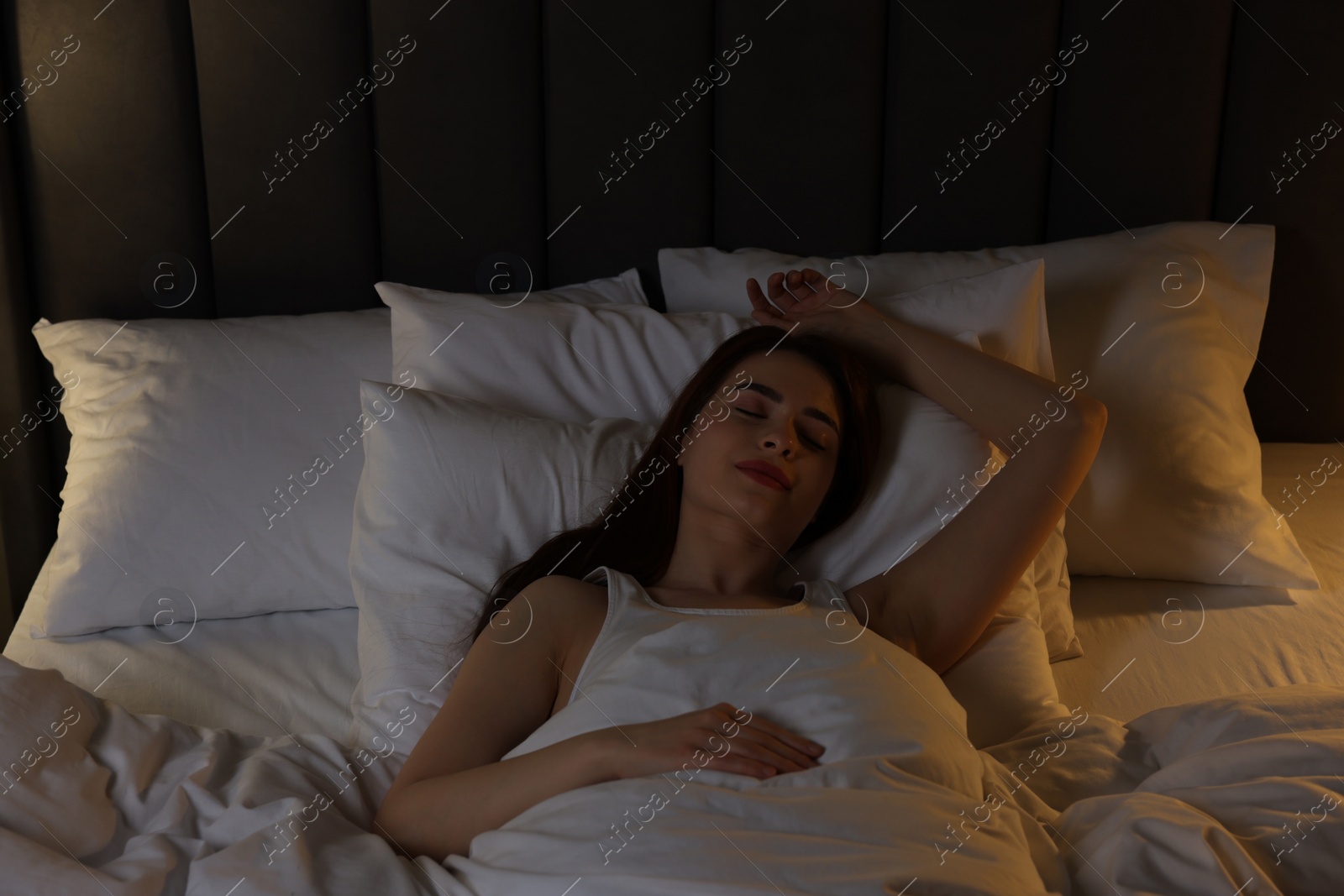 Photo of Beautiful young woman sleeping in bed at night