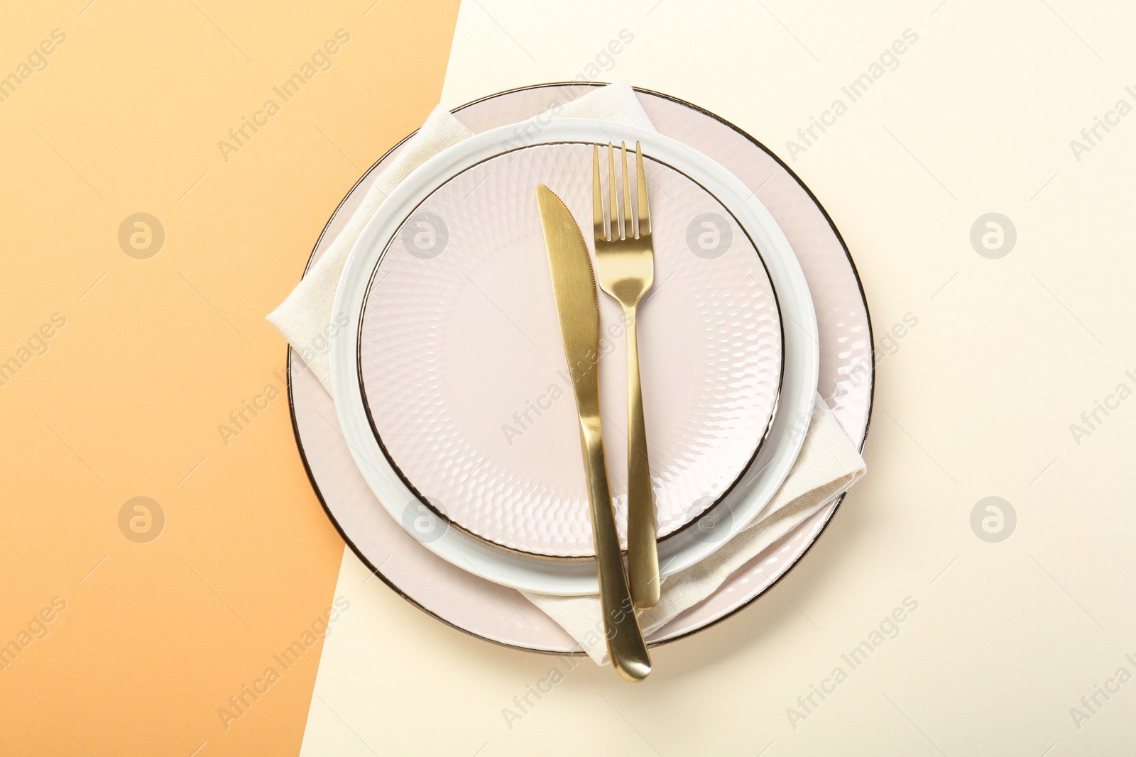 Photo of Ceramic plates, cutlery and napkin on color background, top view