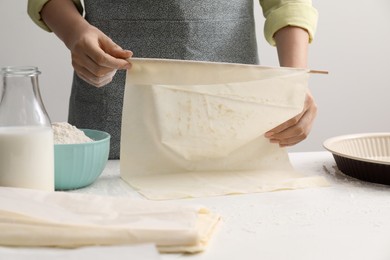 Making tasty baklava. Woman with dough at table, closeup