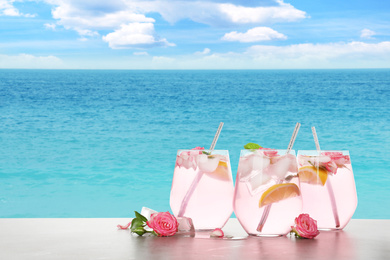 Image of Tasty refreshing drink on table against sea