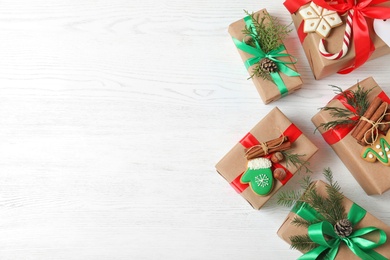 Flat lay composition with Christmas gift boxes on white wooden background. Space for text