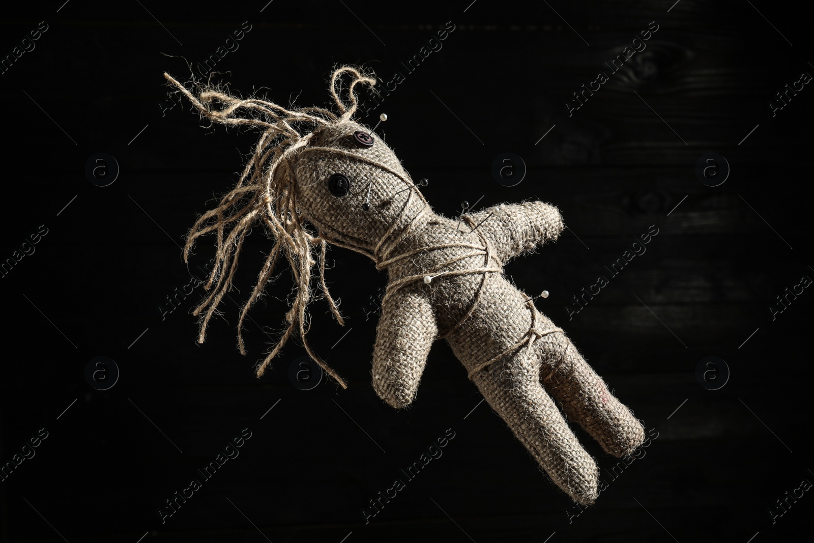 Photo of Female voodoo doll with pins on dark background
