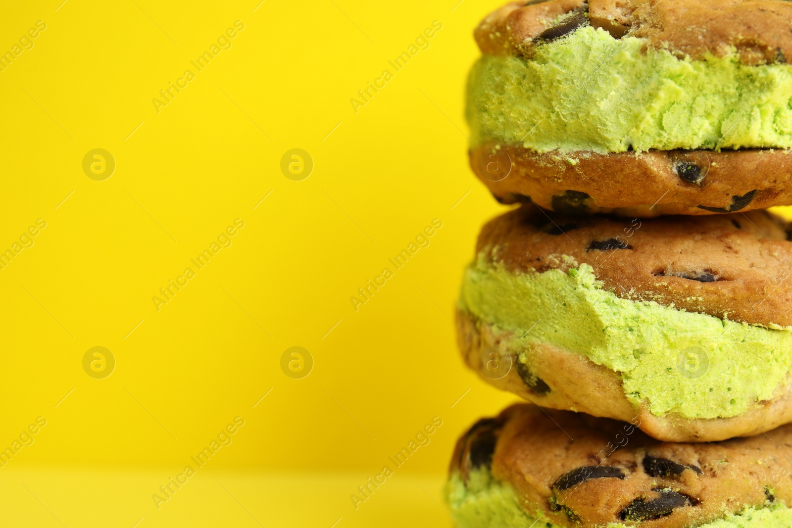 Photo of Sweet delicious ice cream cookie sandwiches on color background, closeup. Space for text