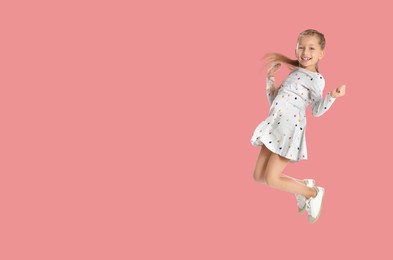 Image of Cute girl jumping on pink background, space for text