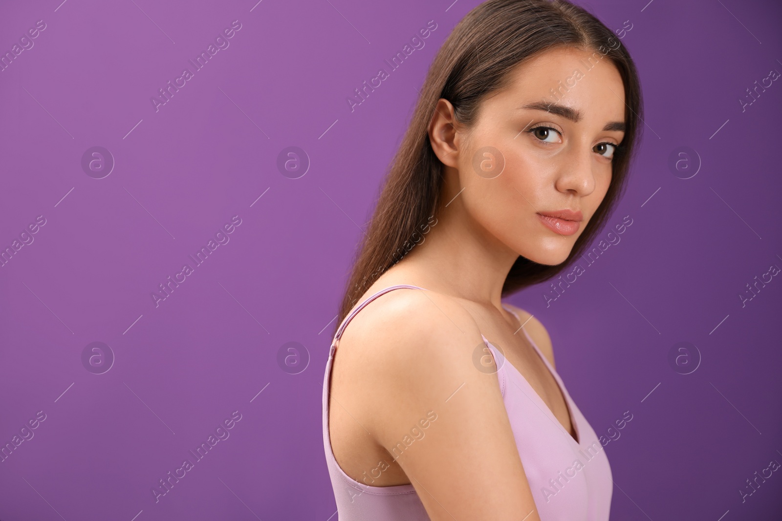 Photo of Portrait of beautiful young woman on purple background. Space for text