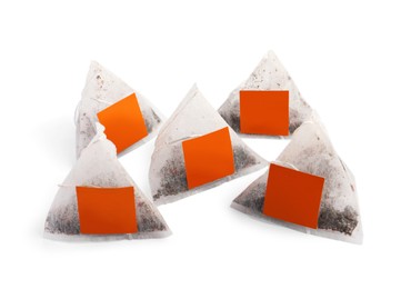 Photo of Many new pyramid tea bags on white background