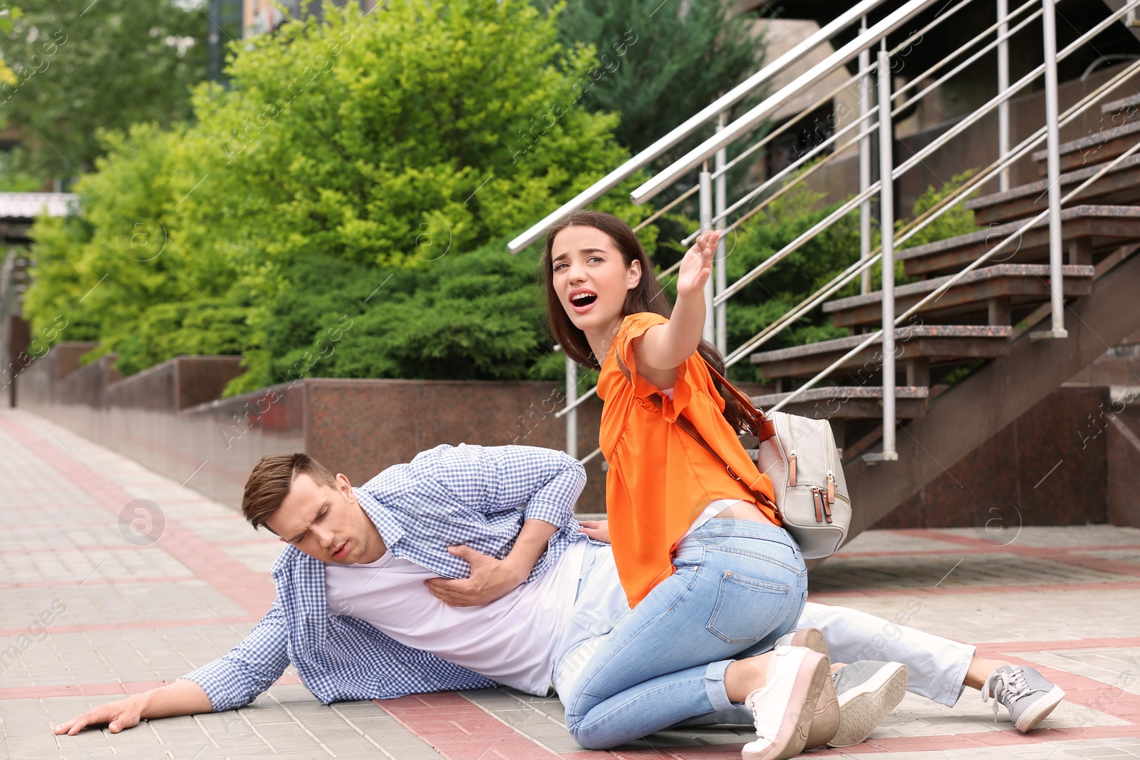 Photo of Passerby helping man with heart attack outdoors