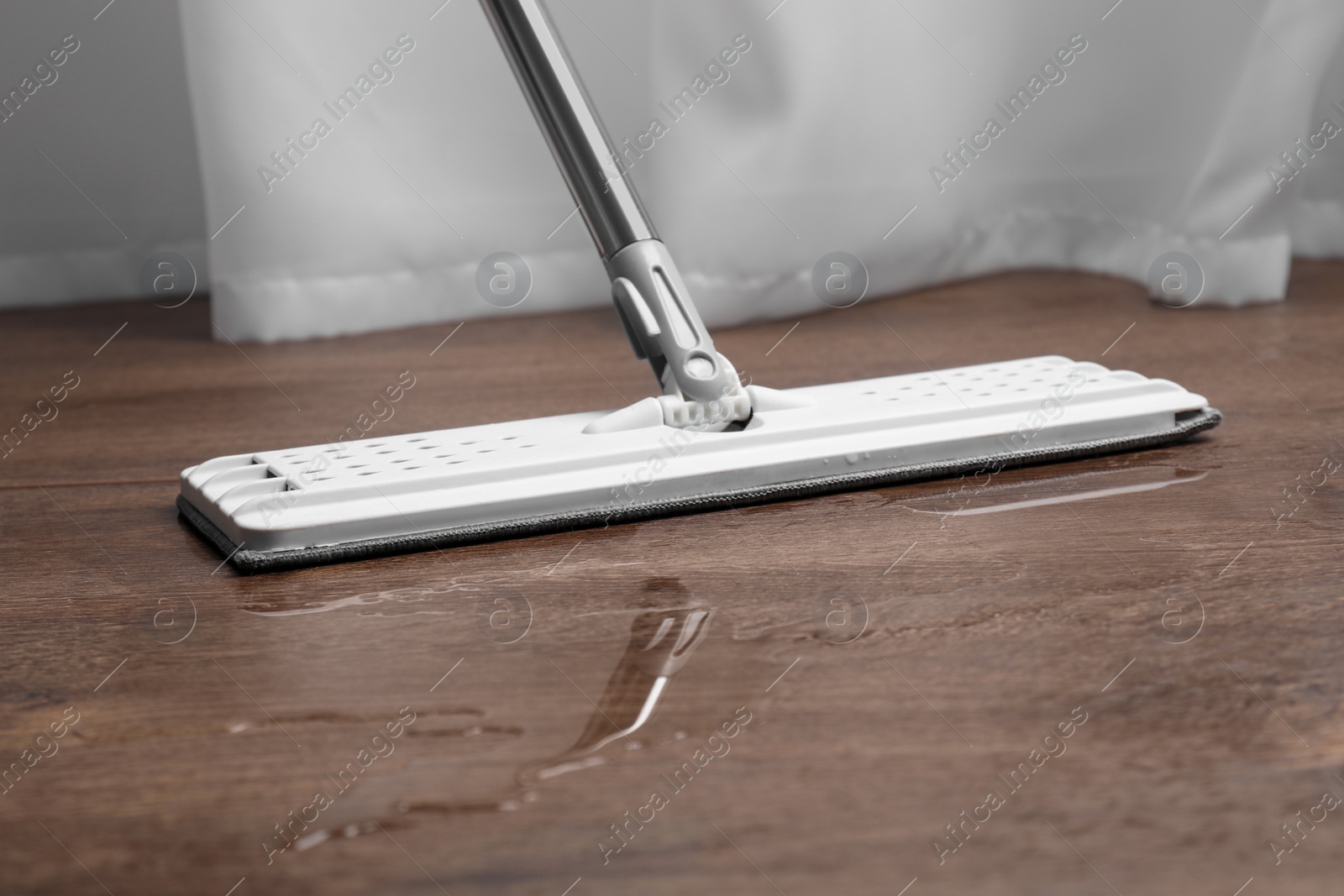 Photo of Cleaning dirty parquet floor with mop, closeup