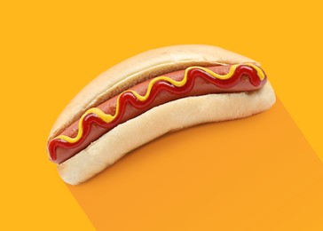 Image of Yummy hot dog with ketchup and mustard on orange background
