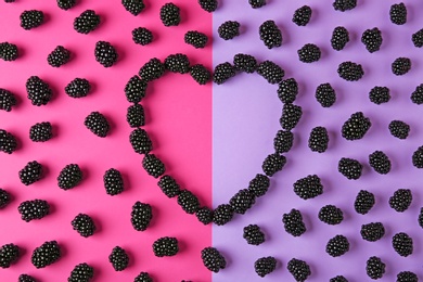Photo of Heart shaped frame made of tasty blackberries on color background, top view with space for text