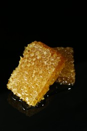 Natural honeycombs with tasty honey on black background