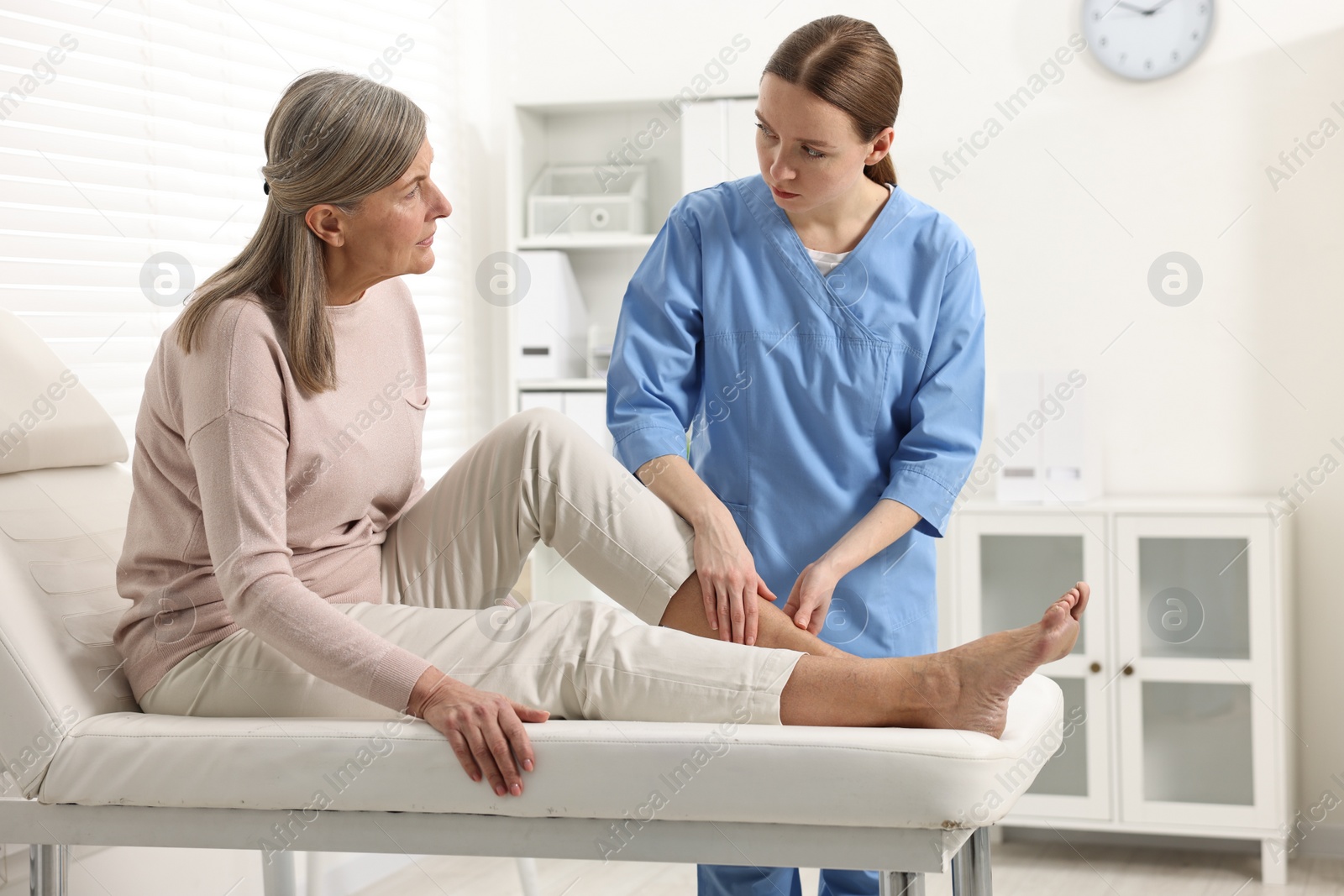 Photo of Arthritis symptoms. Doctor examining patient's leg in hospital