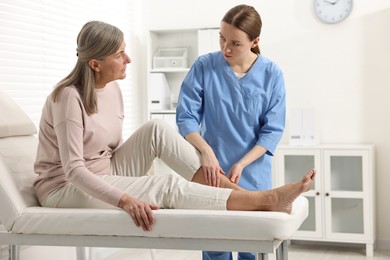 Photo of Arthritis symptoms. Doctor examining patient's leg in hospital