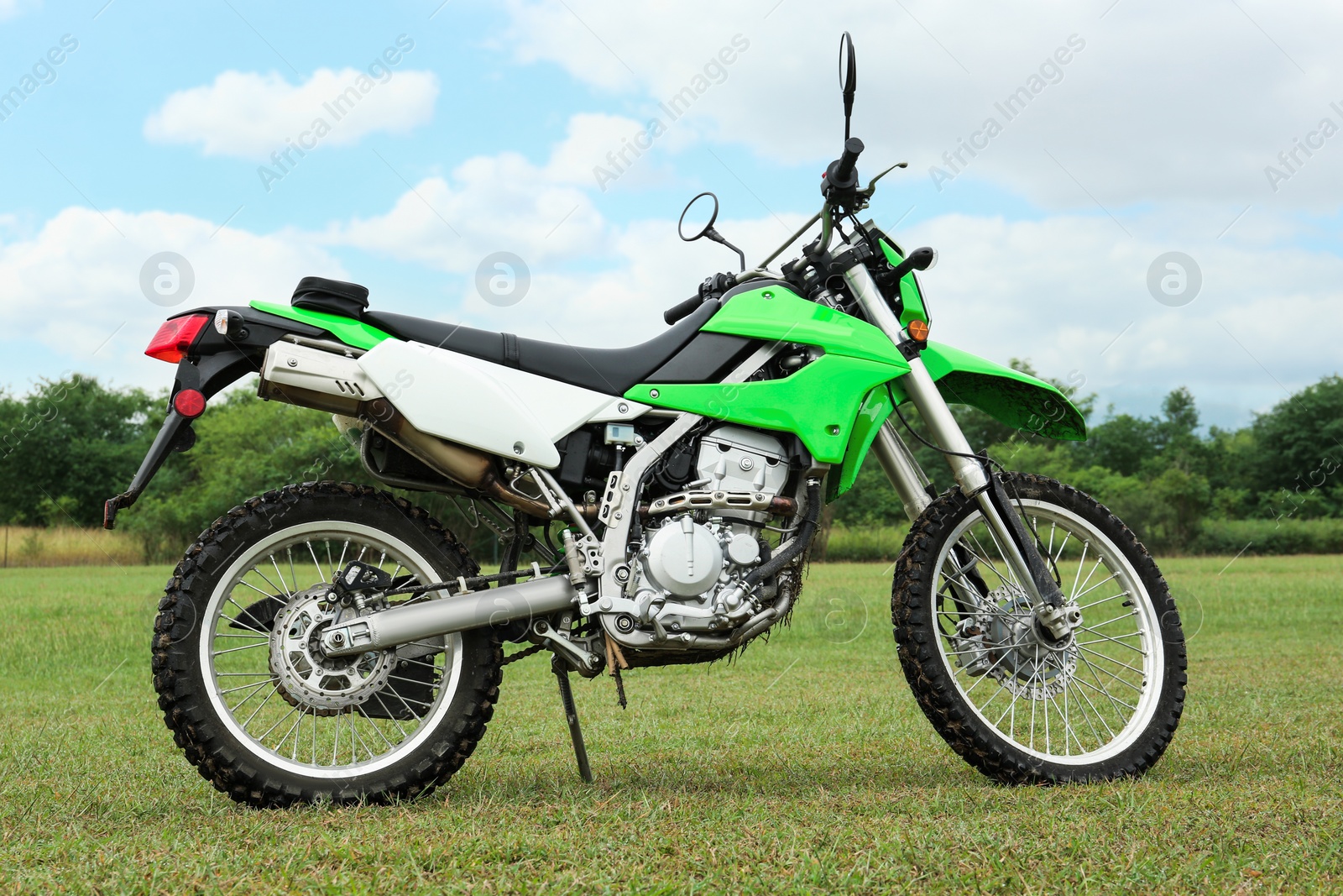 Photo of Stylish cross motorcycle on green grass outdoors