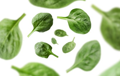 Image of Fresh green spinach leaves in air on white background