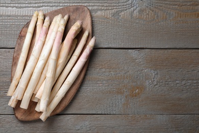 Photo of Fresh white asparagus on wooden table, top view. Space for text