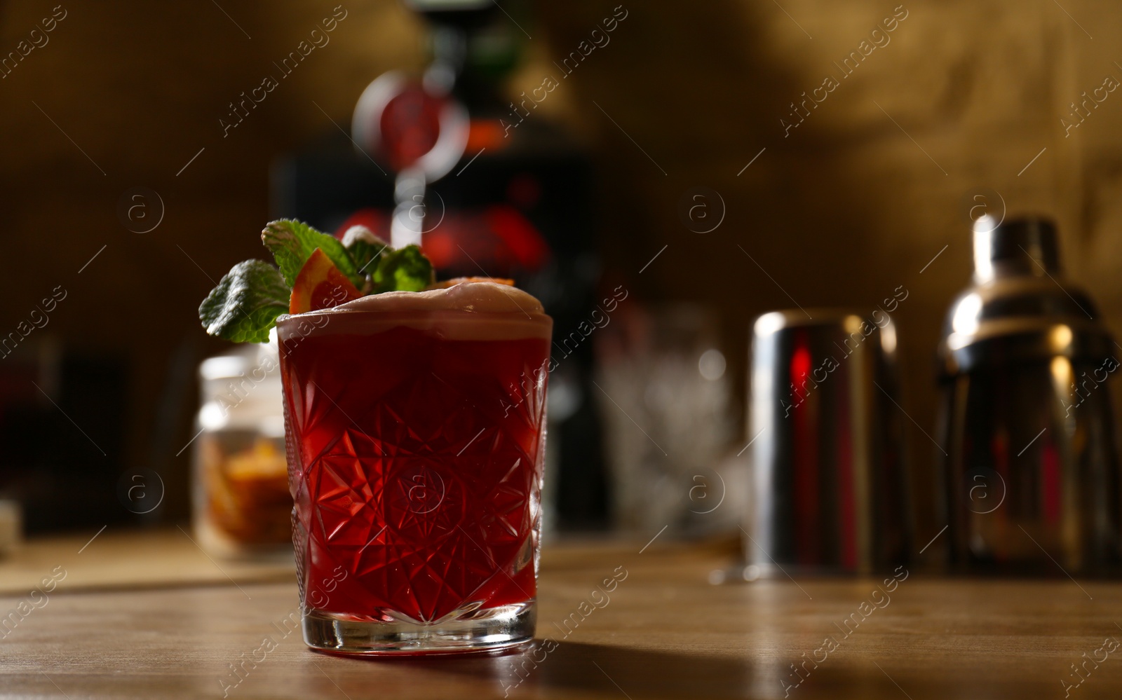 Photo of Glass of fresh alcoholic cocktail on bar counter. Space for text