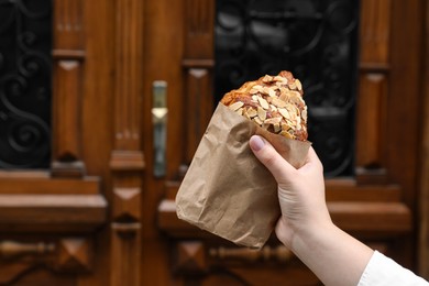 Photo of Woman with delicious croissant outdoors, closeup. Space for text