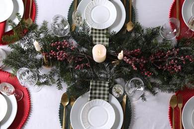 Christmas table setting with festive decor and dishware, flat lay