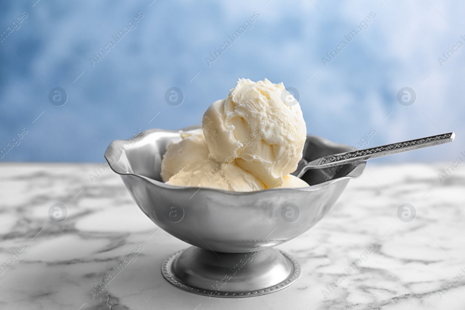 Photo of Bowl with tasty vanilla ice cream on table