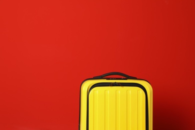 Stylish suitcase against color background, space for text