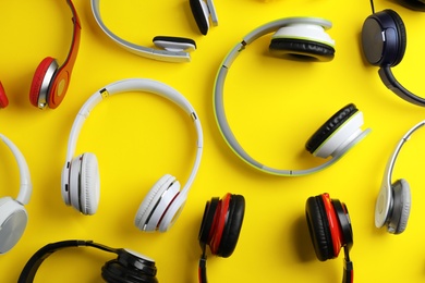 Photo of Many different headphones on color background, top view